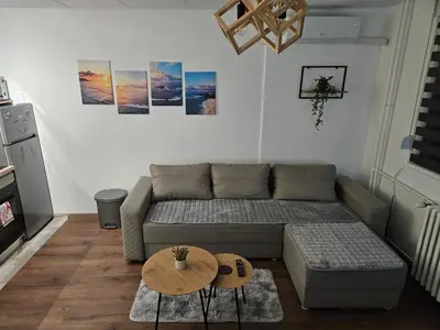 a living room with a couch and a table at Modern Apartment S22 in Niš