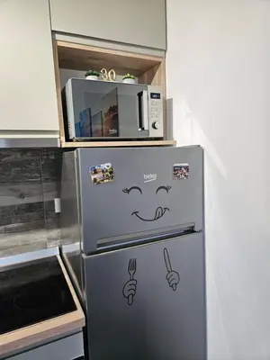 a refrigerator with a face drawn on it in a kitchen at Modern Apartment S22 in Niš