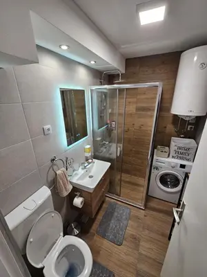 a bathroom with a shower and a toilet and a sink at Modern Apartment S22 in Niš
