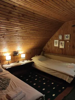a room with two beds and two lamps in a cabin at Drvenica Cabin in Kopaonik