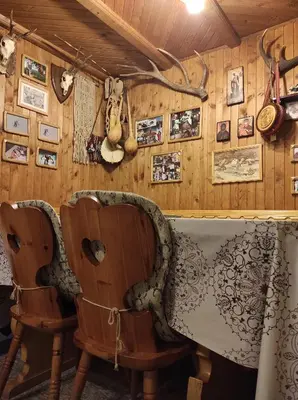 a room with two chairs and pictures on the wall at Drvenica Cabin in Kopaonik