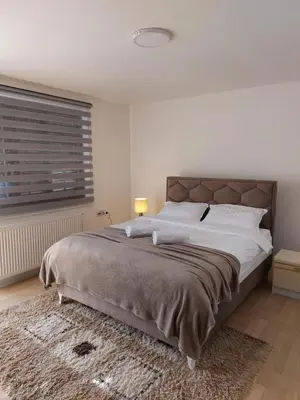 a bedroom with a large bed and a window at R Apartments in Paraćin