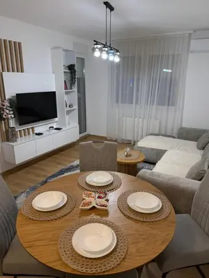 a living room with a table and a couch at Smart Apartmani in Kruševac