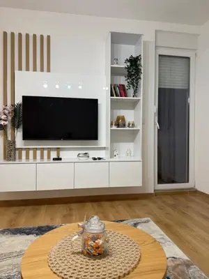 a living room with a tv on a white entertainment center at Smart Apartmani in Kruševac