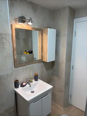 a bathroom with a white sink and a mirror at Smart Apartmani in Kruševac