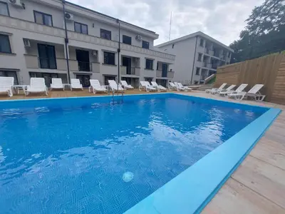 a large blue swimming pool in front of a building at Apartman Nina VB in Vrnjačka Banja
