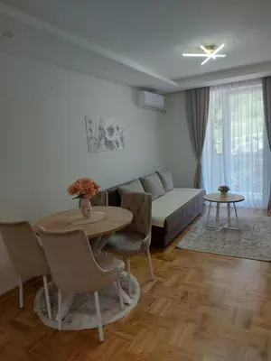 a living room with a table and a couch at Apartman Nina VB in Vrnjačka Banja
