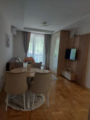 a living room with a table and a couch at Apartman Nina VB in Vrnjačka Banja
