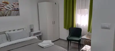 a bedroom with a bed and a chair and a window at Ivan's guesthouse in Paraćin