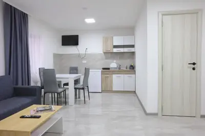 a living room with a table and a kitchen at Ivan's guesthouse in Paraćin