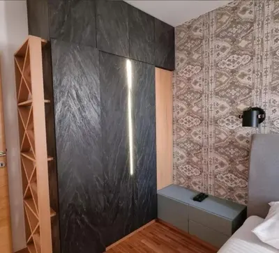 a bedroom with a black wall with a bed and a shelf at Kraljevi Cardaci, Kopaonik, Lux apartman 9C-71 in Kopaonik