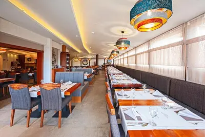 a dining room with tables and chairs in a restaurant at Kraljevi Cardaci, Kopaonik, Lux apartman 9C-71 in Kopaonik