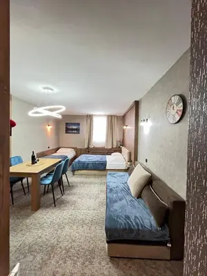 a hotel room with two beds and a couch and a table at R2 KOP Konaci in Kopaonik
