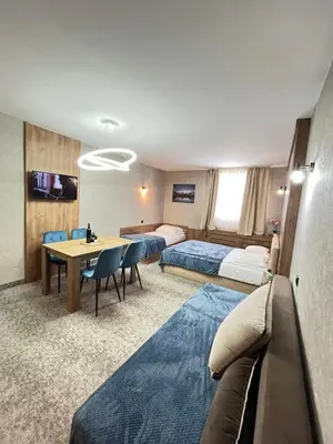 a hotel room with two beds and a table at R2 KOP Konaci in Kopaonik