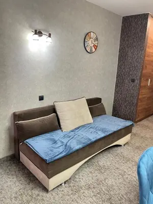 a bed in a room with a clock on the wall at R2 KOP Konaci in Kopaonik
