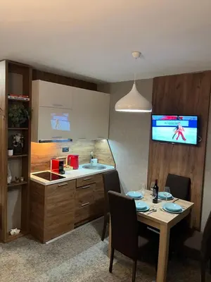 a kitchen with a table and a sink and a tv at R2 KOP Konaci in Kopaonik