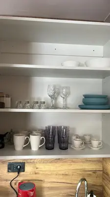 a shelf with cups and dishes on it at R2 KOP Konaci in Kopaonik