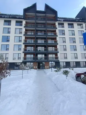 a large building with snow in front of it at Sophie & Sarah Apartments - Residence Hill, Kopaonik in Kopaonik