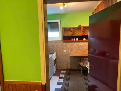 a small kitchen with green walls and a table at Slobo Velickovic in Čerkeška Mala