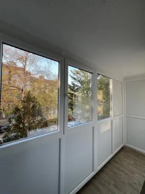 an empty room with three windows in a house at NOMAD Studio in Niš