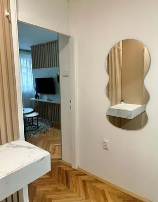 a mirror hanging on a wall in a room at NOMAD Studio in Niš