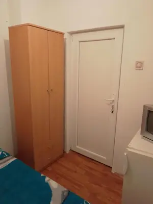 a bedroom with a door and a bed and a television at Sobe za izdavanje Nedeljković in Lukovo