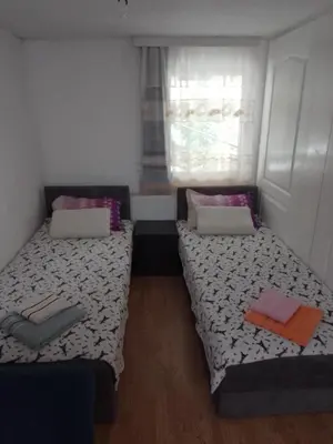 two beds in a small room with a window at Sobe za izdavanje Nedeljković in Lukovo