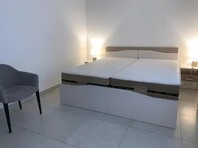 a bedroom with a bed and a desk and a chair at Sofija lux in Jagodina