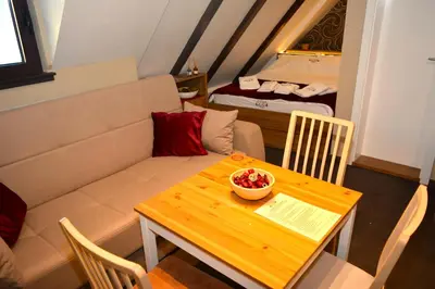 a small living room with a table and a couch at SKI MONTIS apartmani - Kopaonik centar in Kopaonik