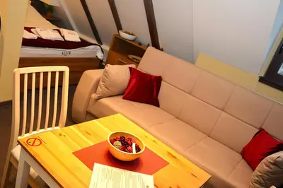 a living room with a couch and a bowl of fruit on a table at SKI MONTIS apartmani - Kopaonik centar in Kopaonik