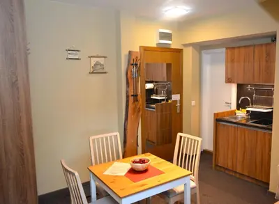 a kitchen and dining room with a table and chairs at SKI MONTIS apartmani - Kopaonik centar in Kopaonik