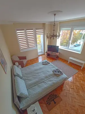 a bedroom with a large bed in a room with windows at Fontana in Kruševac