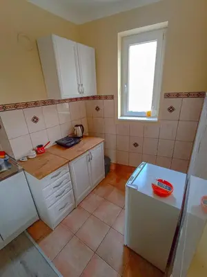 a kitchen with white cabinets and a window at Fontana in Kruševac