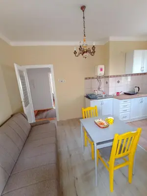 a living room with a table and chairs and a kitchen at Fontana in Kruševac