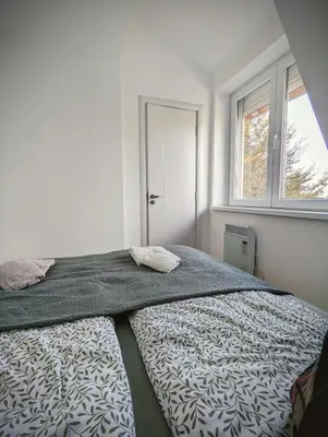 a bed in a white room with a window at Kopaonička priča in Kopaonik