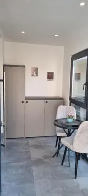 a living room with a table and chairs and a door at Apartman Magic house in Kruševac