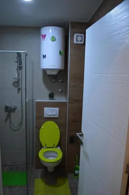 a bathroom with a green toilet and a shower at Apartman S32 Milmari in Raška