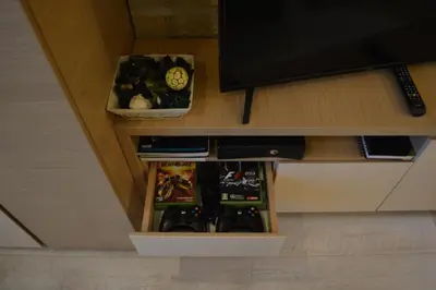 a table with a tv and a shelf with a clock at Apartman S32 Milmari in Raška