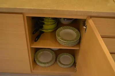 a cupboard with plates and bowls in a kitchen at Apartman S32 Milmari in Raška