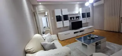 a living room with a white couch and a tv at Centar ljubavi in Kruševac
