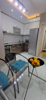 a kitchen with a glass table and a bowl of oranges at Centar ljubavi in Kruševac