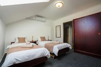 a bedroom with two beds and a dark wood cabinet at Attache Vila in Kruševac