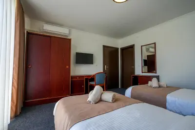 a hotel room with two beds and a tv at Attache Vila in Kruševac