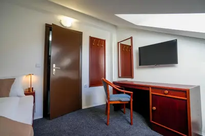 a hotel room with a desk and a tv at Attache Vila in Kruševac
