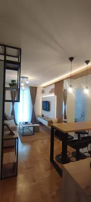 a living room with a table and a couch at Apartman David in Vrnjačka Banja