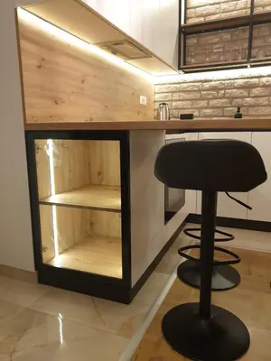 a bar with a black stool at a kitchen counter at Apartman David in Vrnjačka Banja