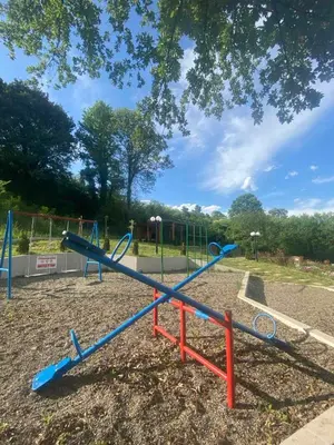 a playground with a blue slide in a park at Apartman David in Vrnjačka Banja