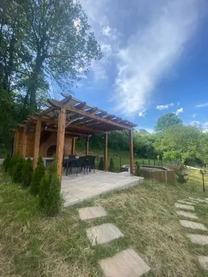 a pavilion with a table and chairs in a field at Apartman David in Vrnjačka Banja