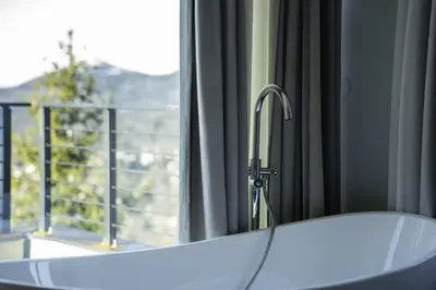 a bath tub in front of a window with a view at Chalet 1600 Kopaonik in Kopaonik