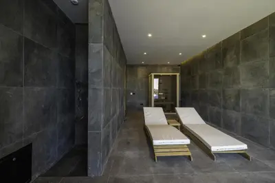 two white benches in a room with a fireplace at Chalet 1600 Kopaonik in Kopaonik